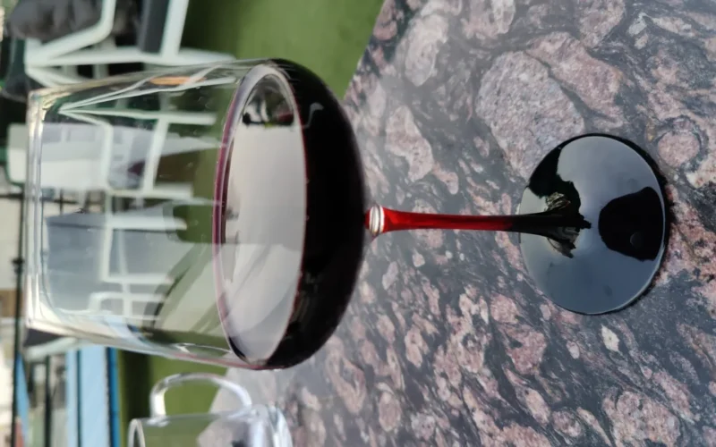 A glass of red wine on a table.