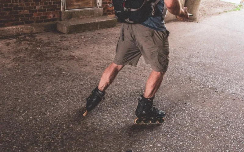 A man actively rollerblading on a rough urban surface, showcasing dynamic movement and outdoor lifestyle.