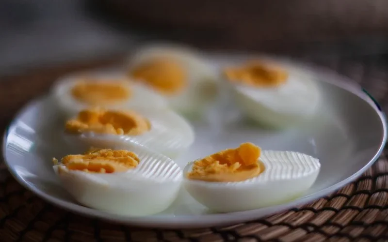 Close-up of sliced boiled eggs with soft yolks on a white plate, perfect breakfast or snack idea.
