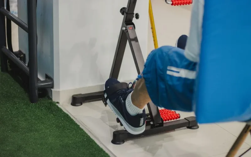 Close-up of a man working out on a stationary bike indoors, focusing on fitness and health.