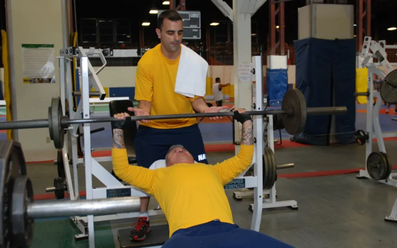 SAN DIEGO (July 26, 2011) Master-at-Arms 1st Class Jason Pingeton spots for Master-at-Arms 1st Class Humphrey Ramos during their bench press regimen at Warehouse Gym at Naval Air Station North Island. An average of nearly 10,000 Sailors do their exercise routines at the gym every month. (U.S. Navy photo by Lt. Nicole R. Schwegman/Released)