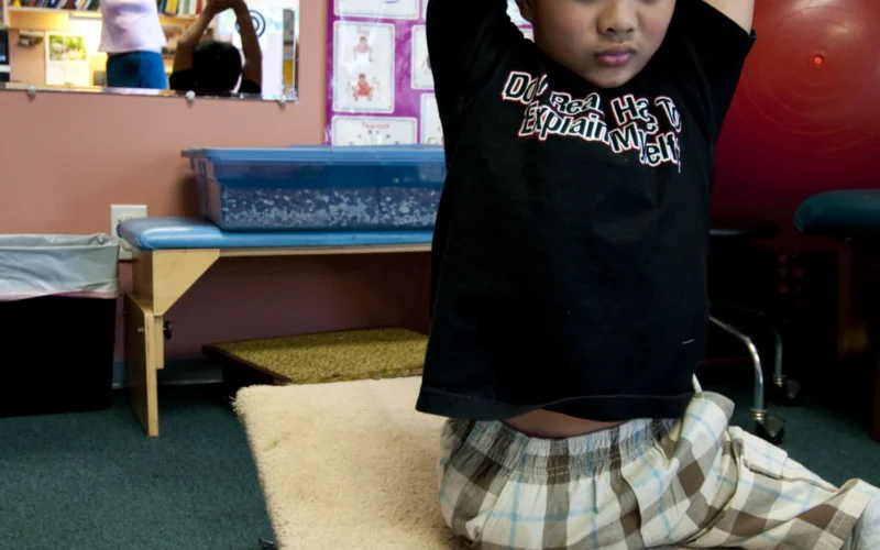 VIRGINIA BEACH, Va. (March 6, 2010) Ten-year-old Joseph Camano performs stretching exercises before a routine physical therapy session with Occupational Therapist Judy Anderson at the Diane Epplein & Assoc. Pediatric Therapy facility. Camano was born with no legs and a malformed right arm and he and his father, Lt. Cmdr. Santiago Camano, are enrolled in the Exceptional Family Member Program (EFMP), a service-wide initiative designed to interface closely with the detailing process to ensure family members receive the care they require and service members can fulfill their career requirements and goals. (U.S. Navy photo by Mass Communication Specialist 1st Class Brien Aho/Released)