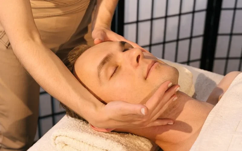 A serene massage setting with a man receiving facial relaxation therapy for ultimate stress relief.