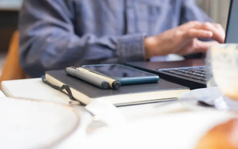 Modern workspace setup with a laptop, notebook, and pens on a desk in Portugal.