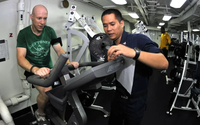 PACIFIC OCEAN (Oct. 24, 2010) Lt. j.g. Neal Soladay, left, from Columbia, S.C., finishes his 20-minute cycle on an exercise bicycle during an indoor triathlon in the gym aboard the aircraft carrier USS George Washington (CVN 73). The triathlon required participants to spend 20 minutes on the treadmill, bicycle and rowing machine. George Washington, the Navy's only permanently forward-deployed aircraft carrier is underway helping to ensure security and stability in the western Pacific Ocean. (U.S. Navy photo by Mass Communication Specialist 3rd Class David A. Cox/Released)
