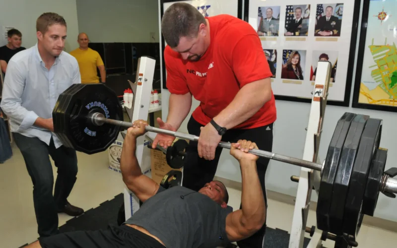 YOKOSUKA, Japan (Sept. 13, 2010) American professional iron man athlete Karl Gillingham spots Hospital Corpsman 2nd Class Ardinis Strickland, from Dallas, during a bench press competition at the Fleet Recreation Center at Commander Fleet Activities Yokosuka. Gillingham visited Yokosuka during his tour of Japan installations to meet with forward-deployed service members. (U.S. Navy photo by Mass Communication Specialist 1st Class Brock A. Taylor/Released)