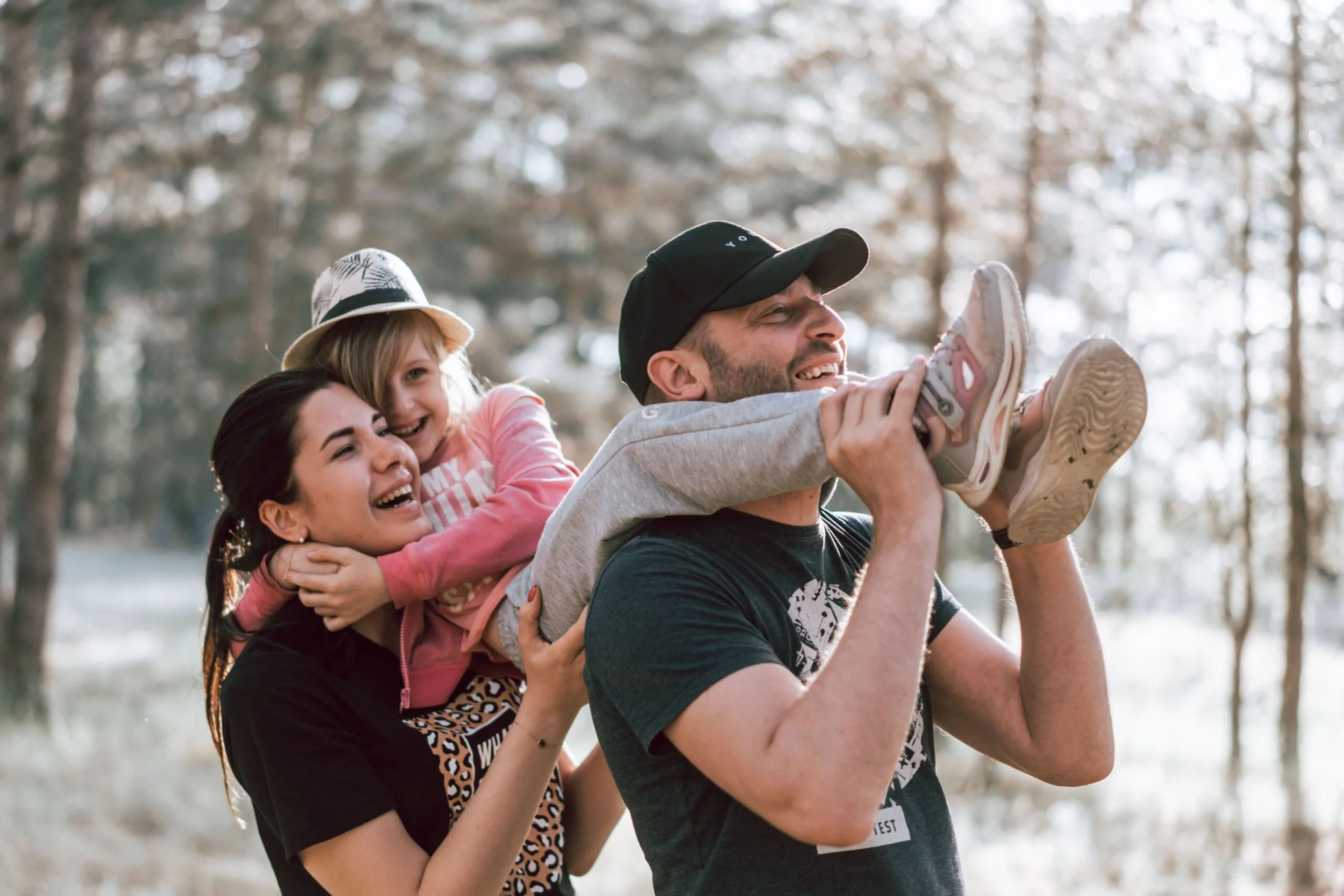 Happy family having fun in a forest, capturing joyful bonding moments.