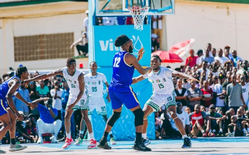 Outdoor basketball game with players competing, surrounded by a large, enthusiastic crowd.