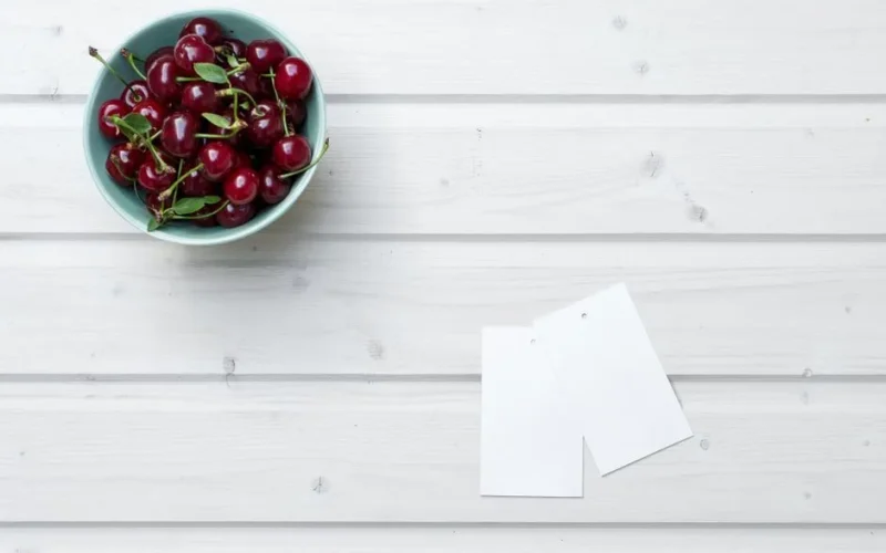 A bowl of ripe cherries on a wooden table, offering freshness and a hint of summer.