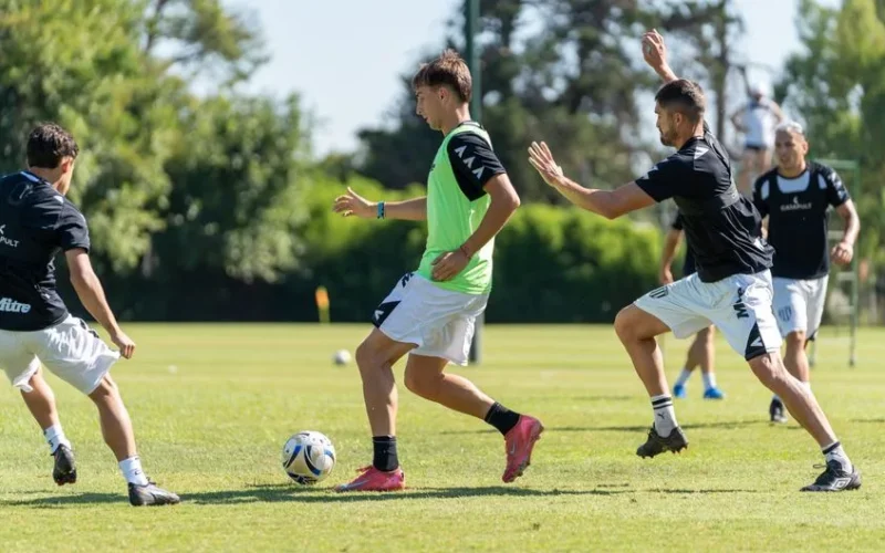 Dynamic soccer players in action during an outdoor training session on a sunny day.