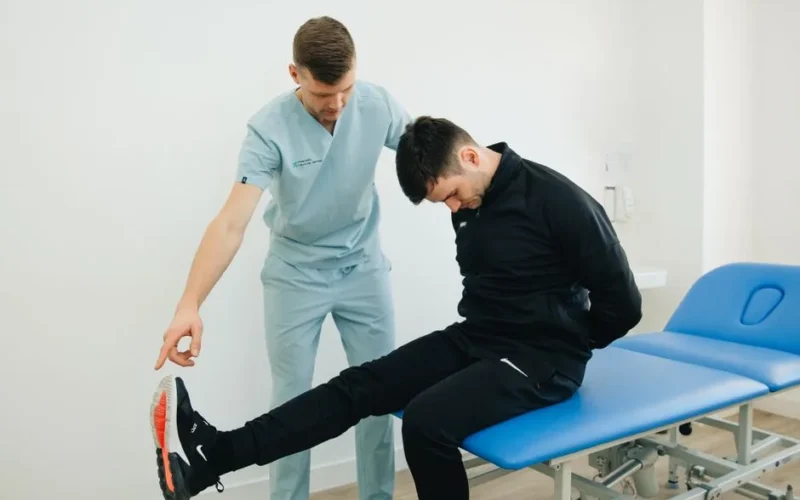 Physiotherapist instructing a patient on rehabilitation exercises in a clinic setting.