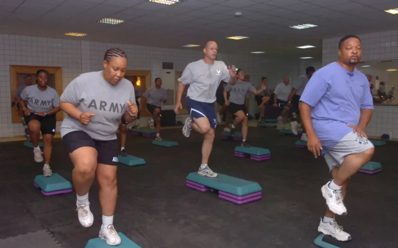 Soldiers, civilians, and Airmen who reside on Camp Taji, Iraq, enjoy a step aerobics workout, July 1, at the Durable Gym. Word about the step aerobics workout spread, and the class grew from having about 20 people to having almost 50 participants. "I first heard about step aerobics through friends that were already involved in the program. It sounded like a lot of fun, like a stress reliever, and for the ones going on a regular basis, they were seeing results," said Sgt. Jasmine Burks, a Junction City, Kan., native and medic with the 1st Sustainment Brigade.