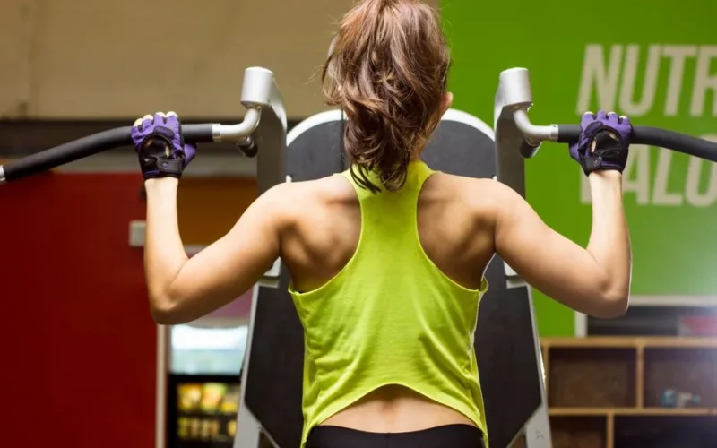 Woman in gym working out on exercise machine for a healthy lifestyle.