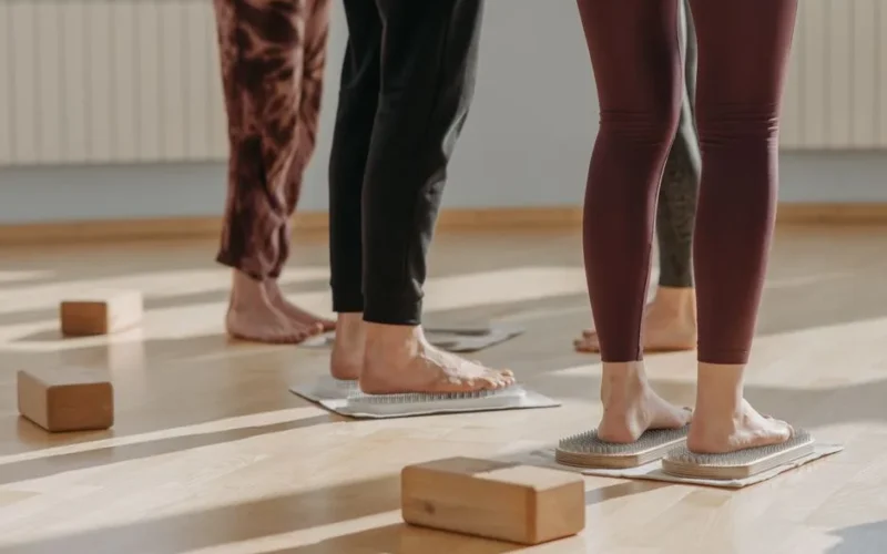 Close-up of feet during a yoga class focusing on balance and posture indoors.