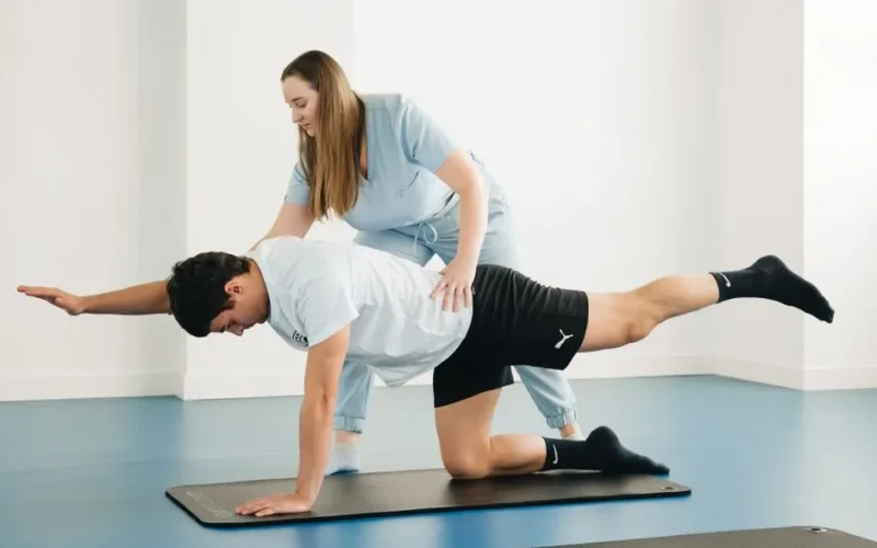 A physiotherapist assists a patient with exercises in a modern clinic setting.