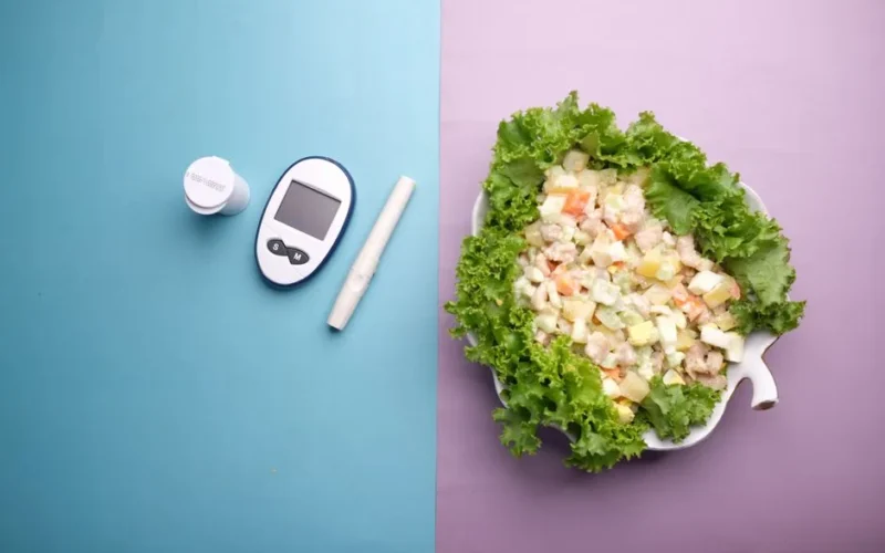 Top view of diabetes equipment and fresh salad representing healthy living.