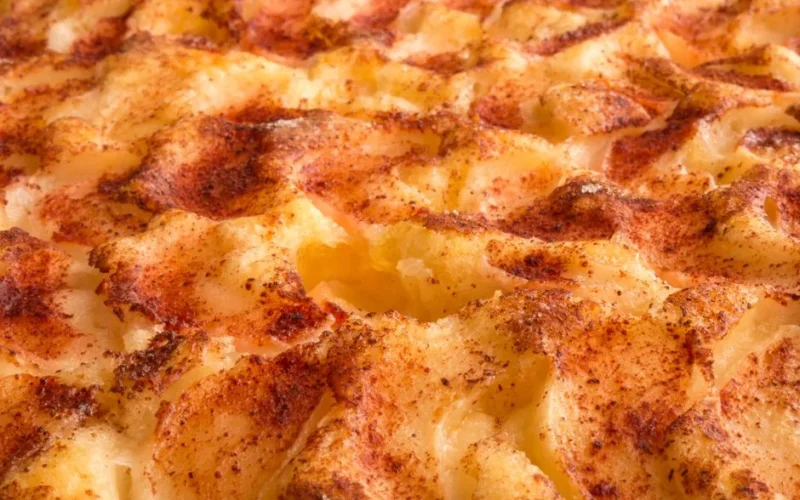 Delicious close-up of grilled mashed potato topping with golden brown crust and spices.