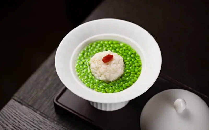 A gourmet soup dish featuring green peas and rice in a white bowl, perfect for food photography.