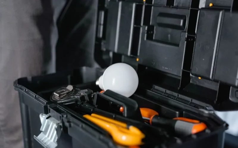 Open toolbox containing various tools and a light bulb.