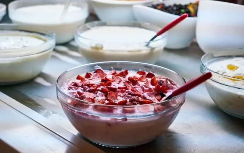A variety of homemade yogurt dishes with fresh fruit toppings in bowls, perfect for breakfast or a healthy snack.
