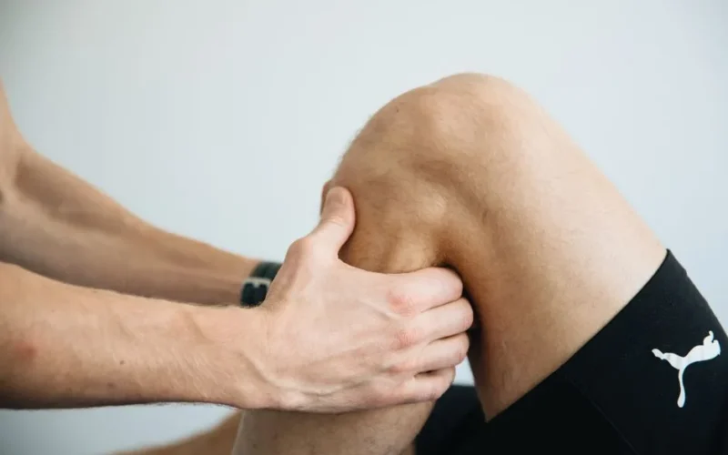 Detailed image of a physiotherapy session focusing on knee massage treatment.