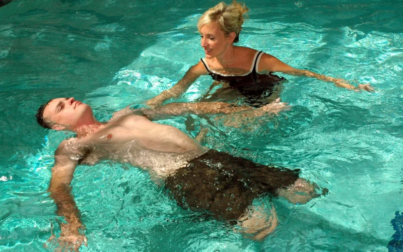 SAN DIEGO (Oct. 1, 2009) Lynn A. Boulanger, a Naval Medical Center San Diego occupational therapist, assists Marine Corps Staff Sgt. Jesse A. Cottle, a bilateral amputee, while he performs back strengthening exercises as part of the Comprehensive Combat and Complex Casualty Care program. The program manages severely wounded, ill or injured patients from medical evacuation through inpatient care, outpatient rehabilitation, and eventual return to active duty or transition from the military. (U.S. Navy photo by Mass Communication Specialist 3rd Class Jake Berenguer/Released)