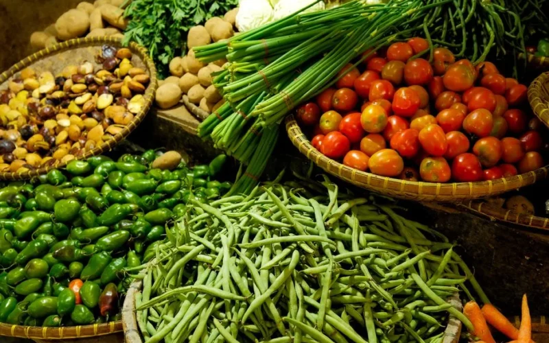 Colorful assortment of fresh vegetables in a local market setting.