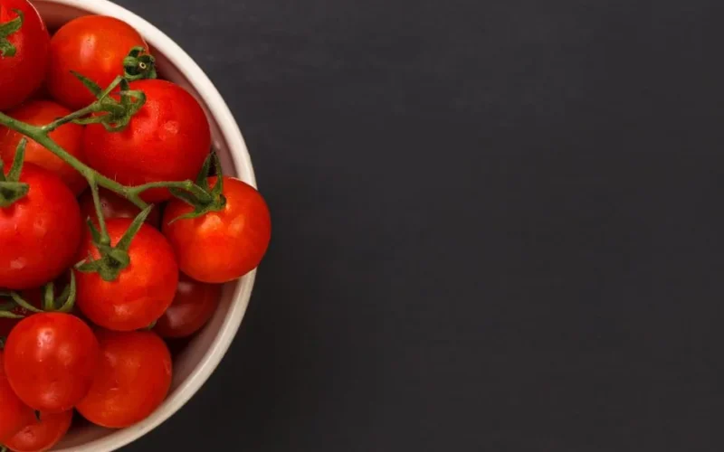 Close-up of ripe red tomatoes in a bowl providing ample copy space for text.