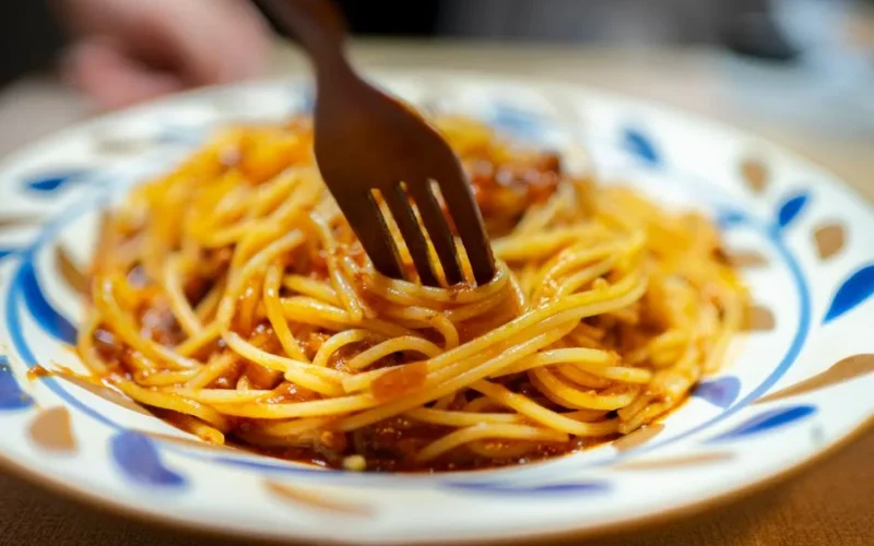 Delicious spaghetti with rich tomato sauce served on an artistic plate, fork ready to dig in.