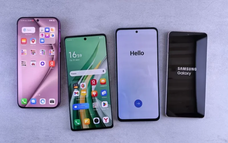 Four modern smartphones showcasing home screens, applications, and startup logos on a sleek surface.