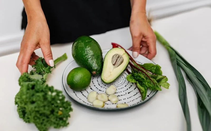 Top view of assorted fresh ingredients including avocado and kale on a plate. Perfect for healthy eating themes.